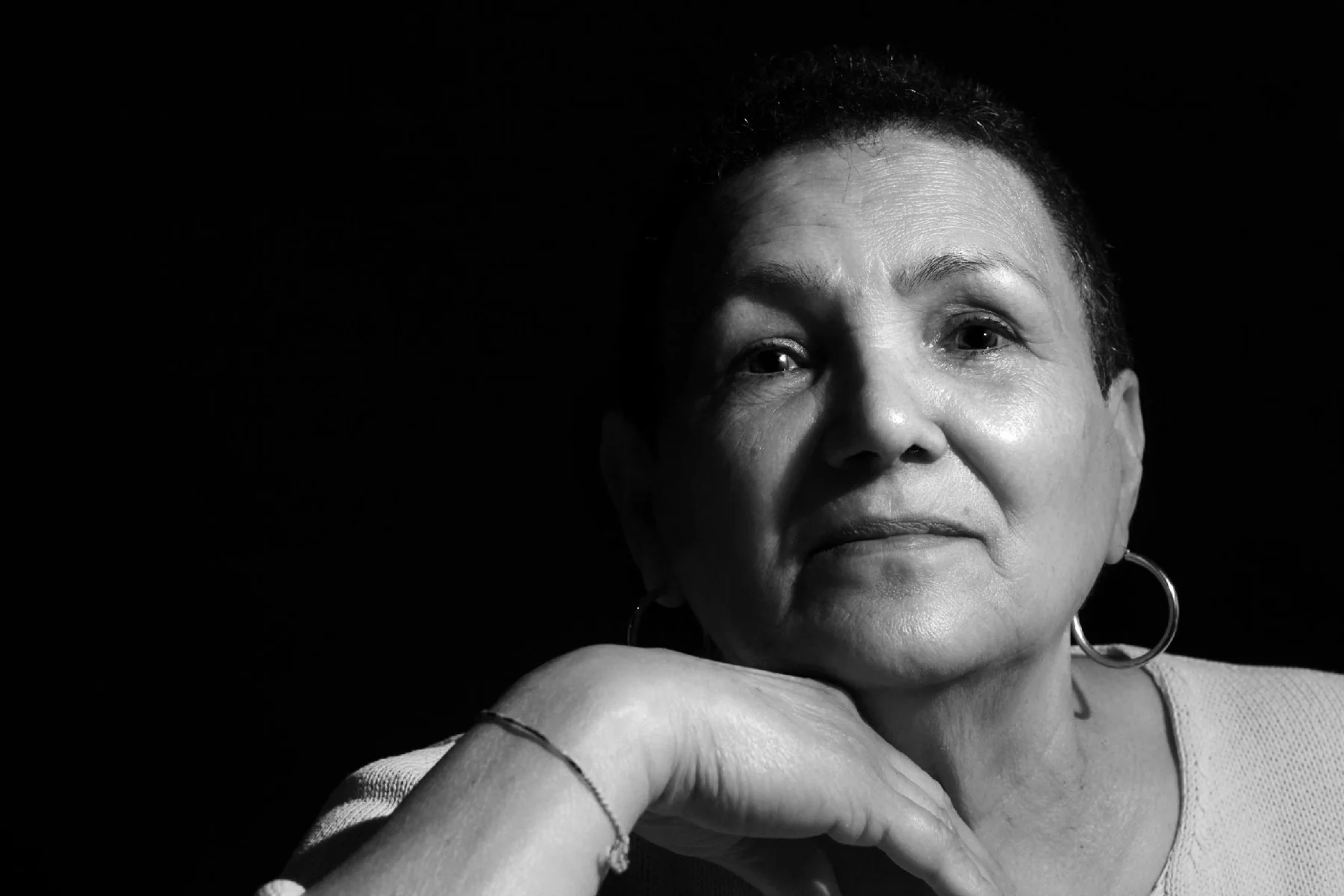 Black-and-white portrait of a woman resting her chin on her hand