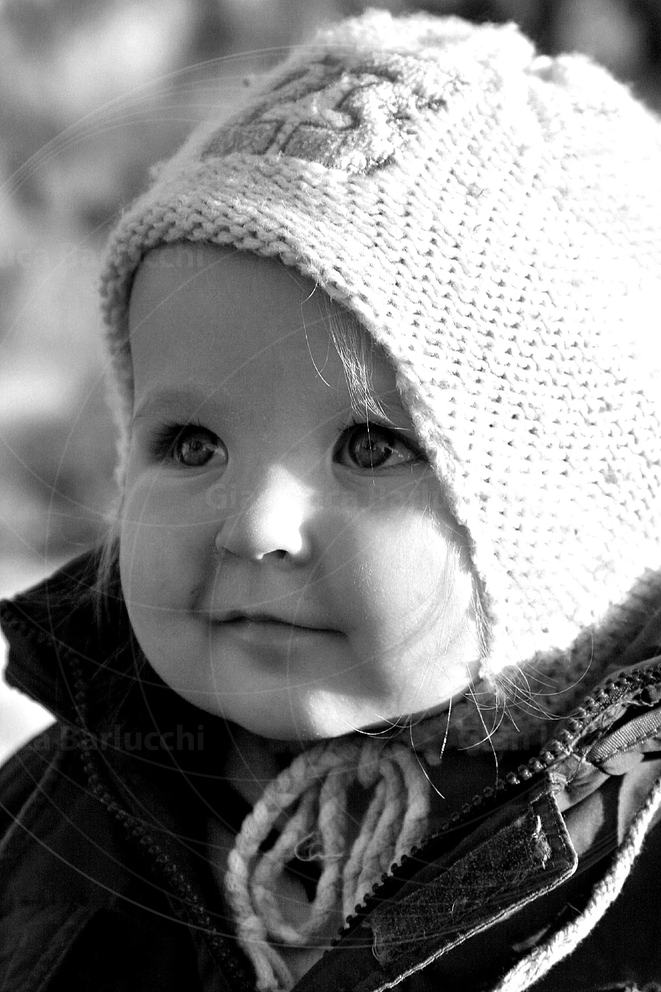 Black-and-white portrait of a baby wearing a knitted hat
