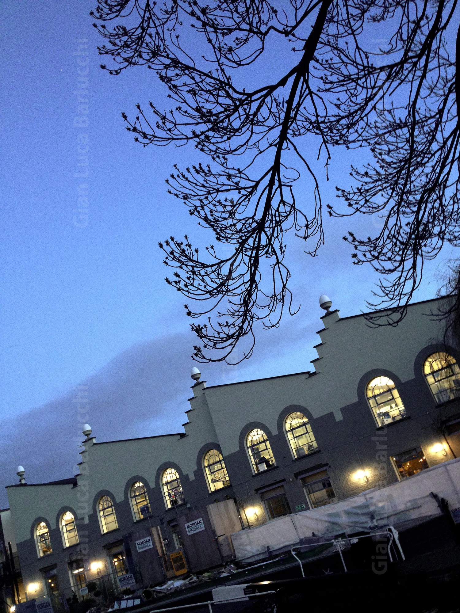 Arched windows of a Camden Town building beneath a blue evening sky