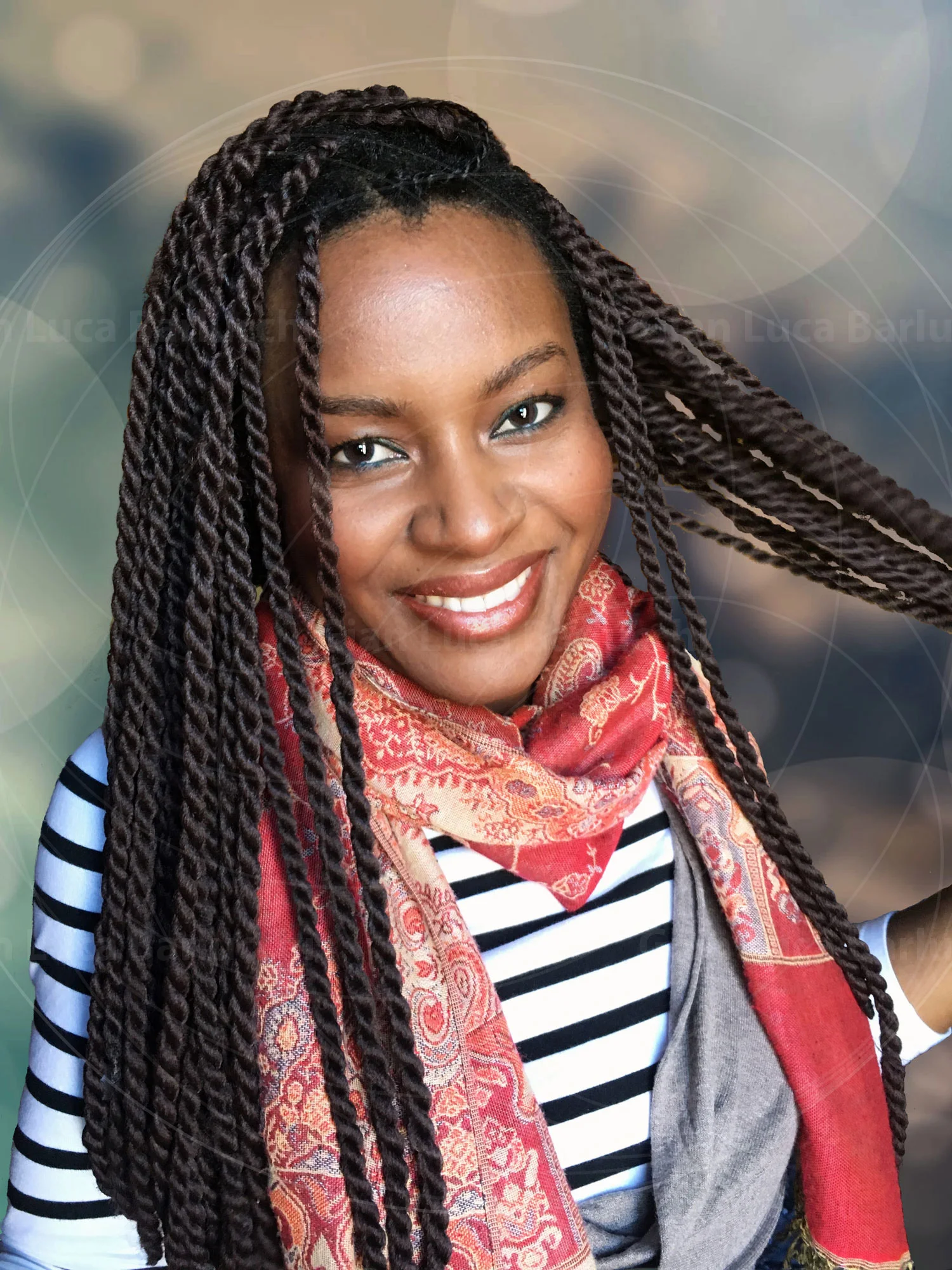 Smiling woman with long braids, a striped top and a patterned scarf