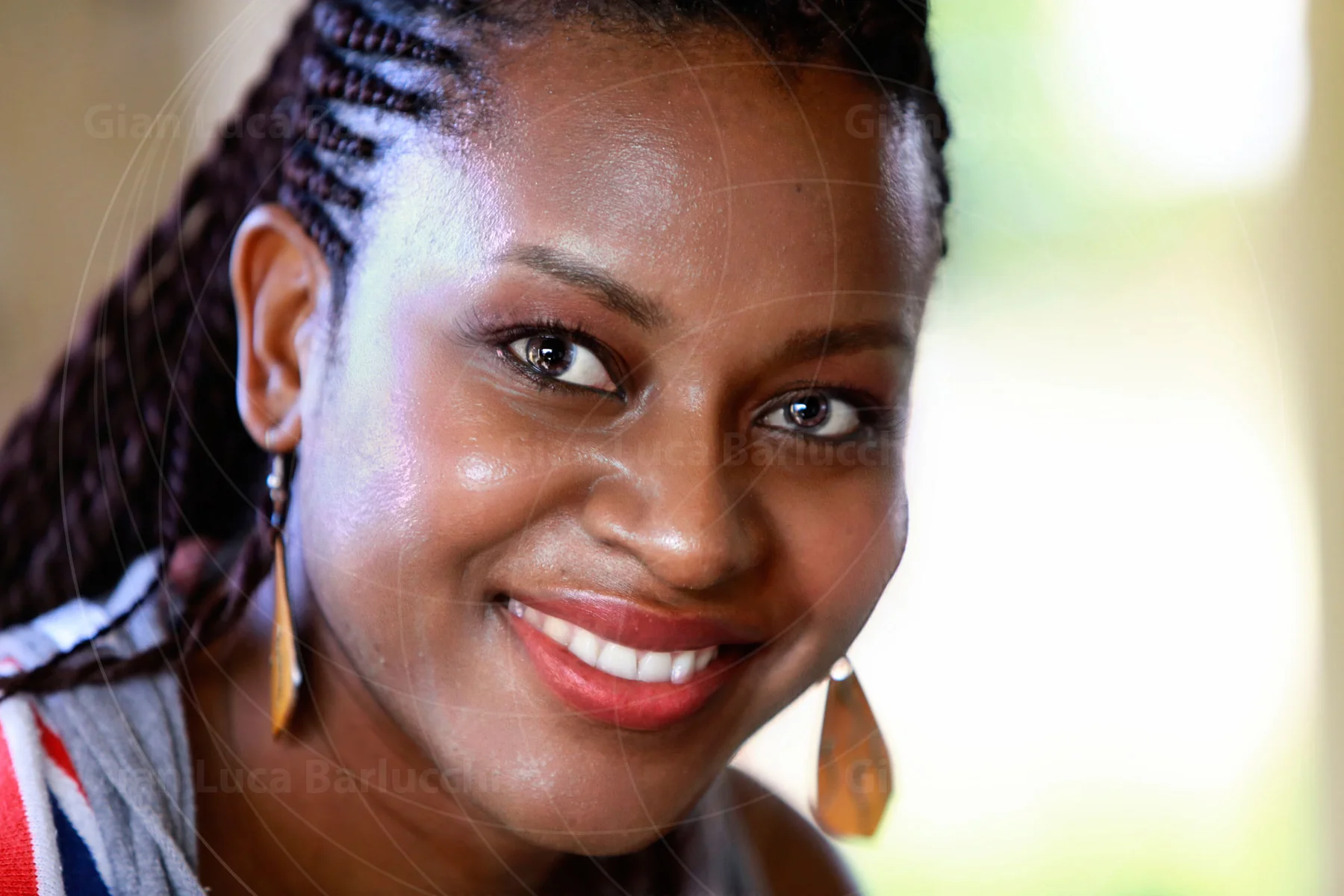 Smiling woman with braided hair and gold-coloured earrings