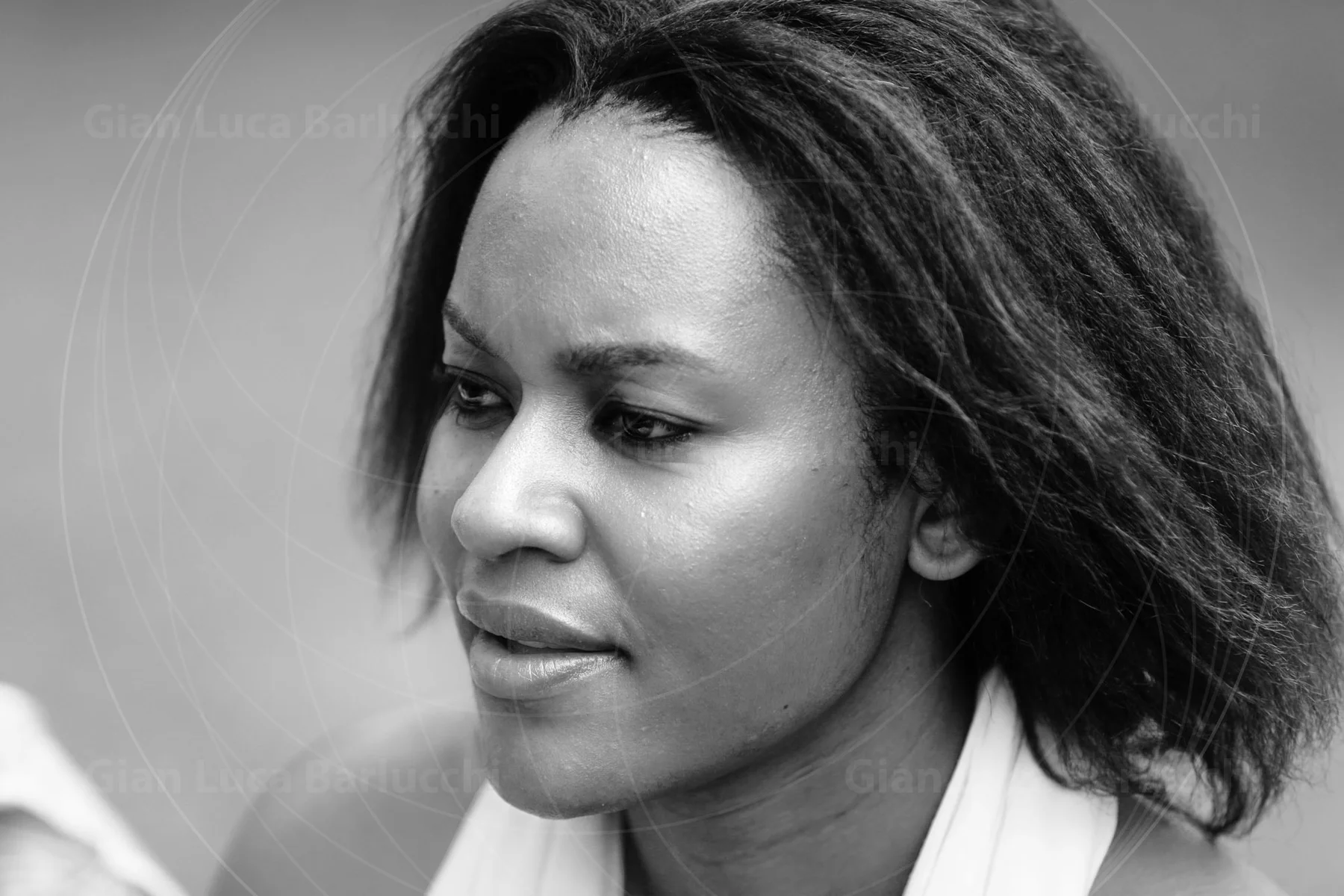 Black-and-white portrait of a woman with shoulder-length hair looking to the side