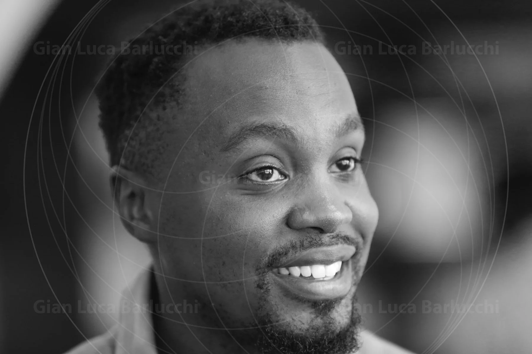 Black-and-white portrait of a smiling young man