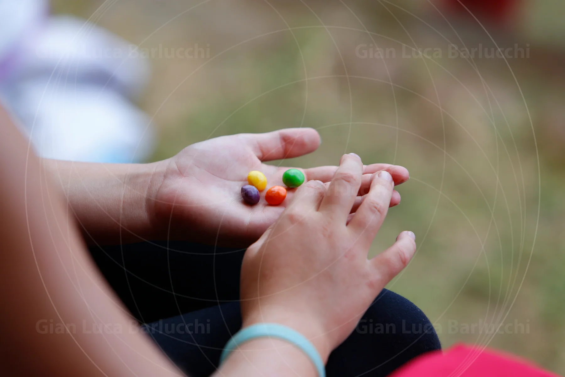Child's hands holding a few brightly coloured sweets