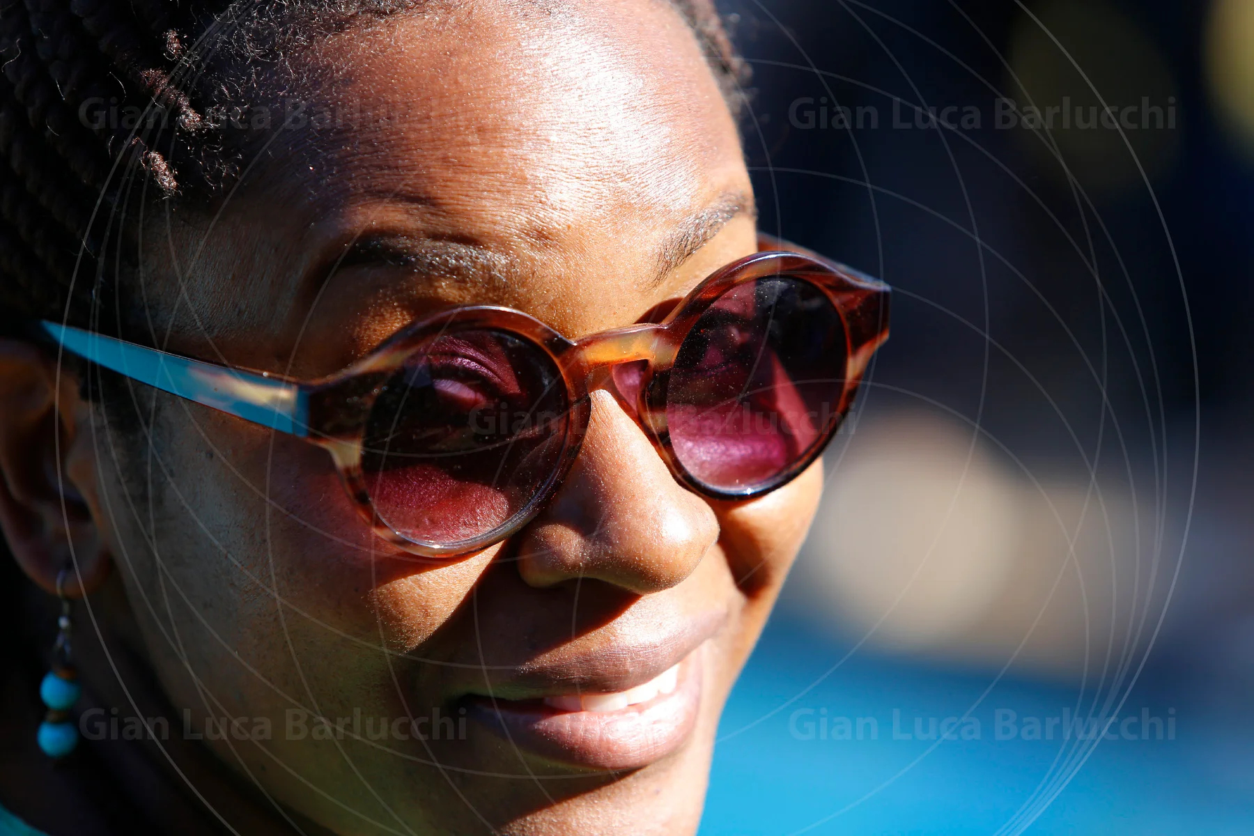 Close-up of a woman wearing round, tinted sunglasses