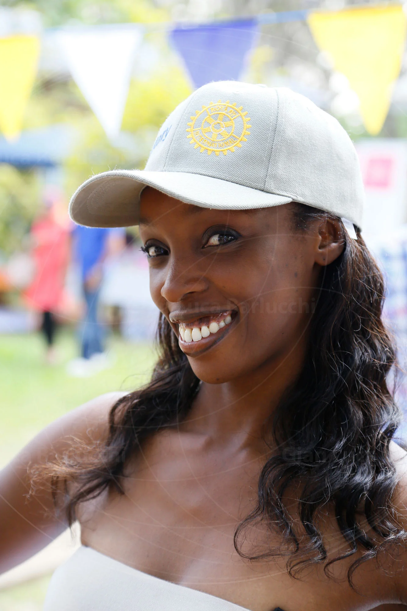 Smiling woman wearing a pale baseball cap outdoors
