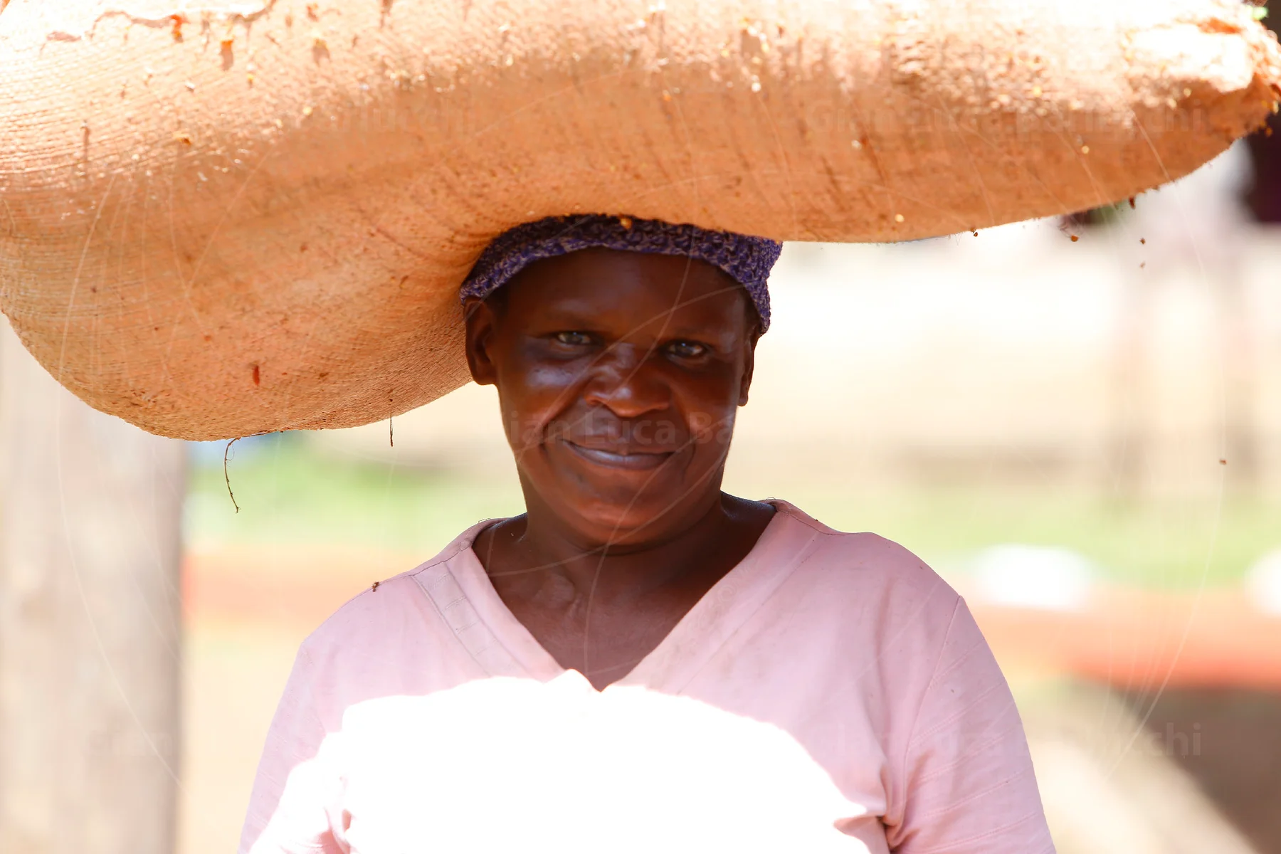 Woman carrying a large sack balanced on her head