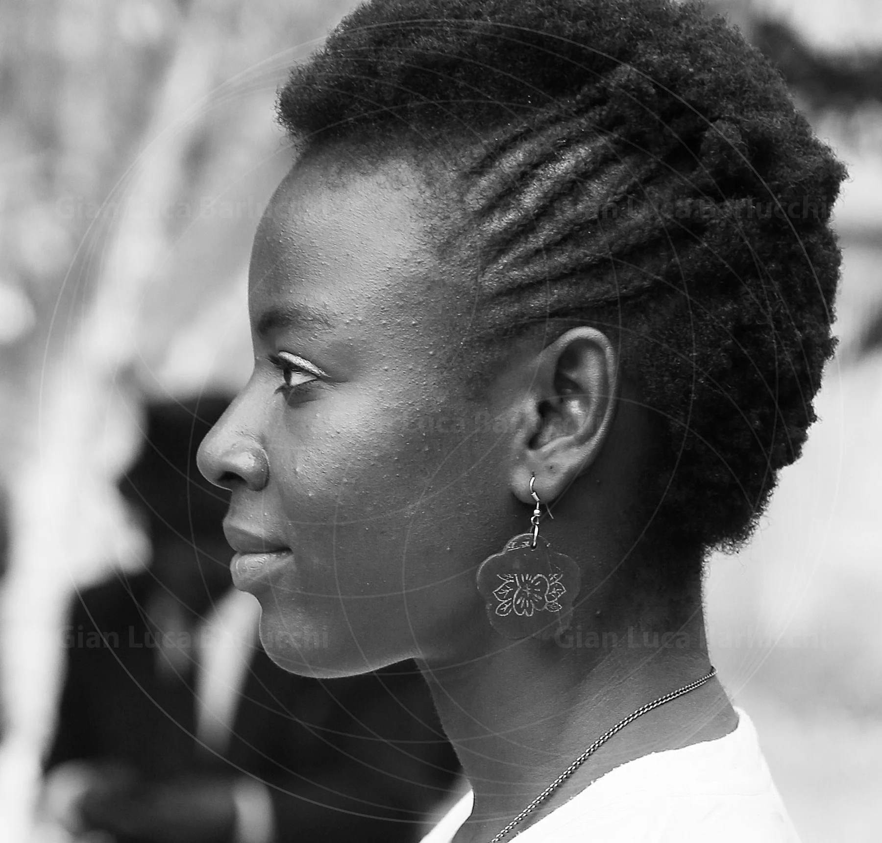 Black-and-white profile of a woman with braided hair and a dangling earring