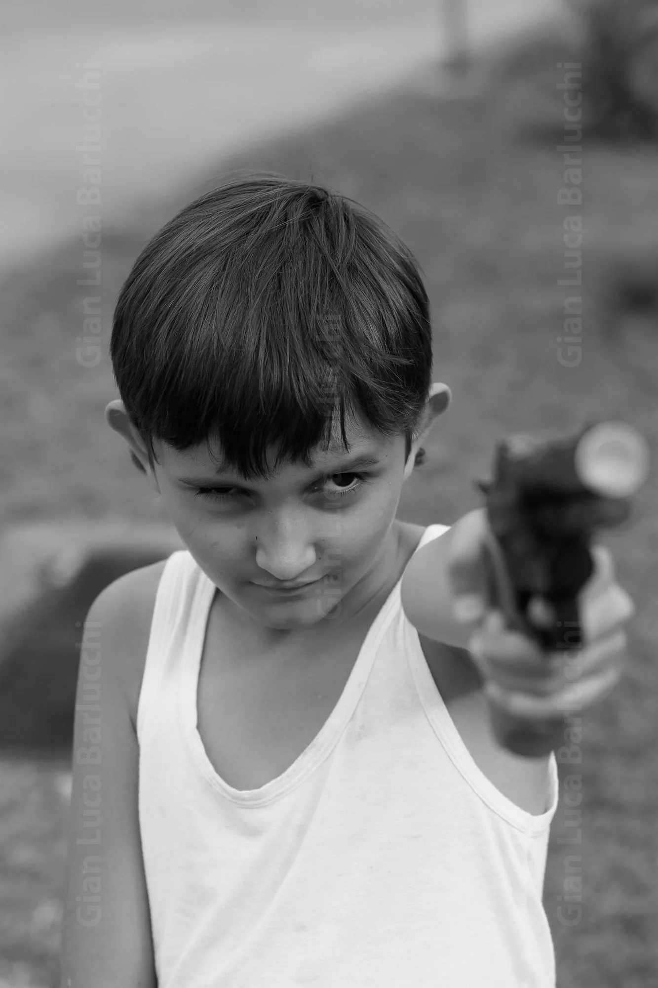 Black-and-white photograph of a child pointing an object toward the camera